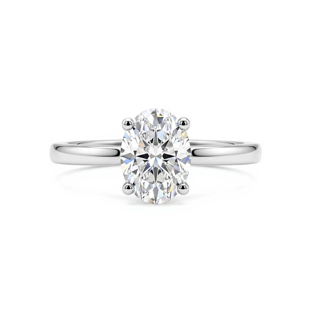 An oval moissanite solitaire ring in a four-prong 925 sterling silver setting with a plain polished band, on a white background