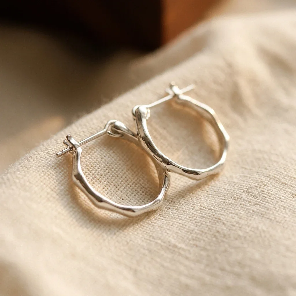 Irregular polished 925 sterling silver wavy hoop earrings, photographed on a white background